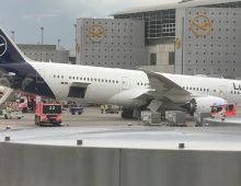A Lufthansa Dreamliner aircraft rests on its nose in front of a terminal at Frankfurt Airport after the nose landing gear collapsed. Employees were injured in the incident. Photo: Mike Seeboth/dpa