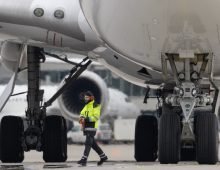 A Lufthansa ramp agent looks tiny next to a Boeing 747 ready for takeoff at Frankfurt Airport. The constantly fluctuating fuel prices also have an indirect impact on airfare prices. Photo: Boris Roessler/dpa