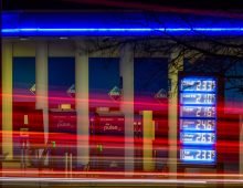 The lights of passing cars can be seen in front of the price board of a petrol station in Chemnitz. The trucks supply petrol stations in the region. Photo: Hendrik Schmidt/dpa