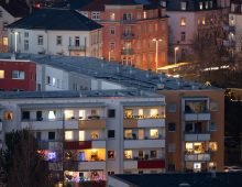 Individual windows in a residential building in the Gorbitz district of Dresden shine brightly, while other densely built-up residential buildings in the district are illuminated at dusk. Photo: Sebastian Kahnert/dpa